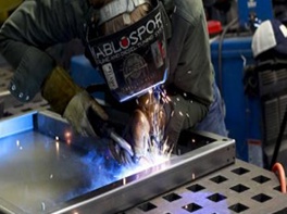 Welder welding a stainless steel blind cleaner cabinet
