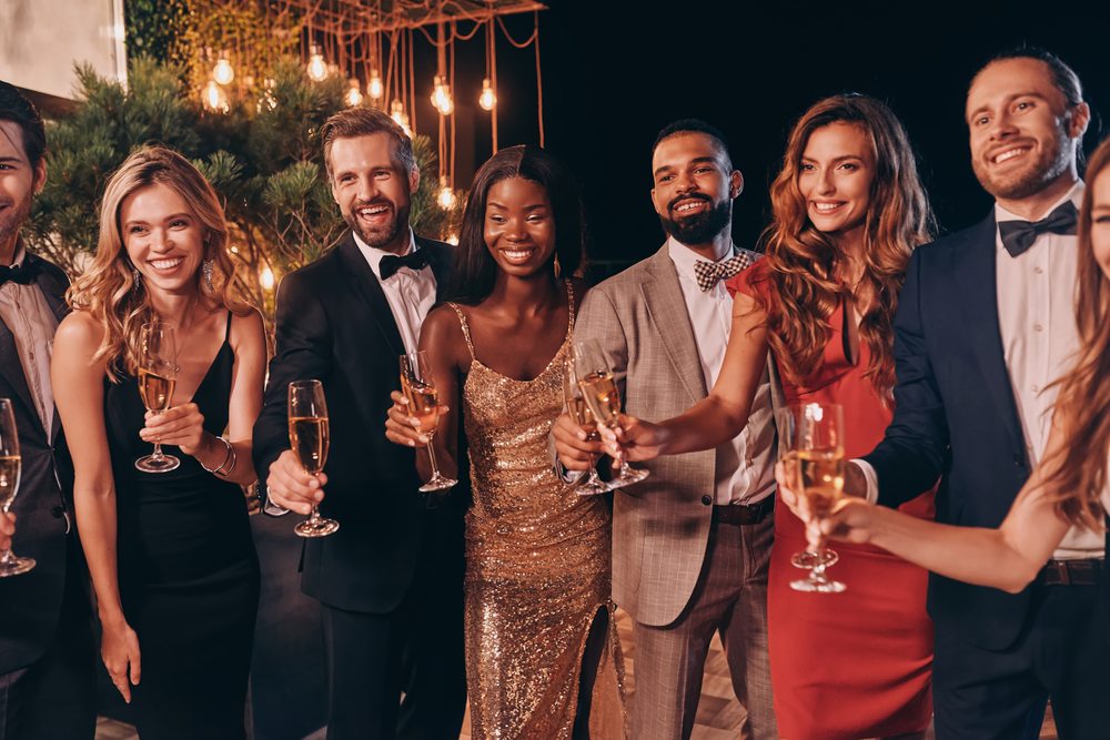 Guests raising their glasses together at an evening celebration