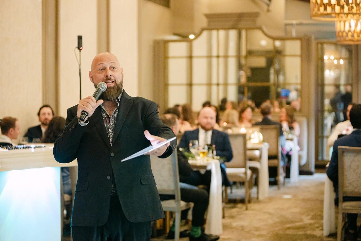 Joe speaking into a microphone while hosting a wedding reception