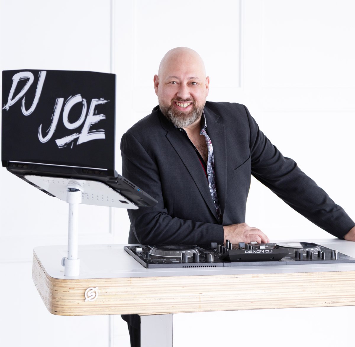 Joe Seyler smiling beside his DJ booth