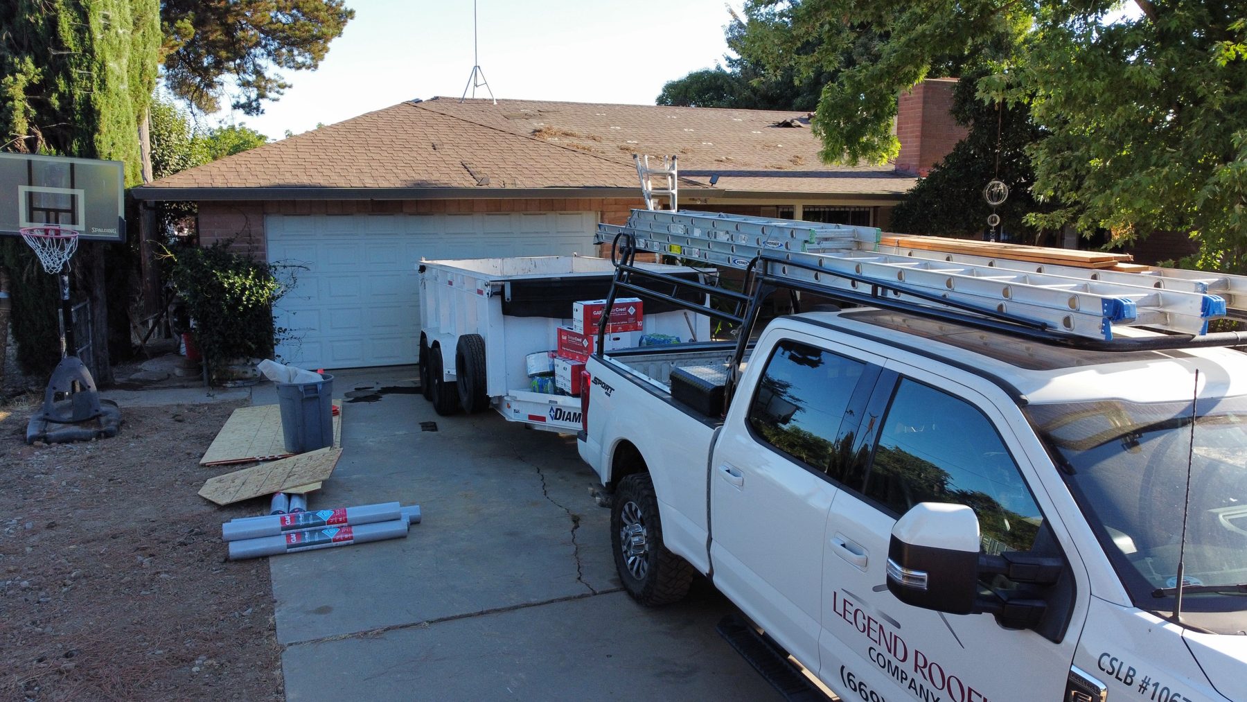 Legend Roofing truck and dump trailer on a job