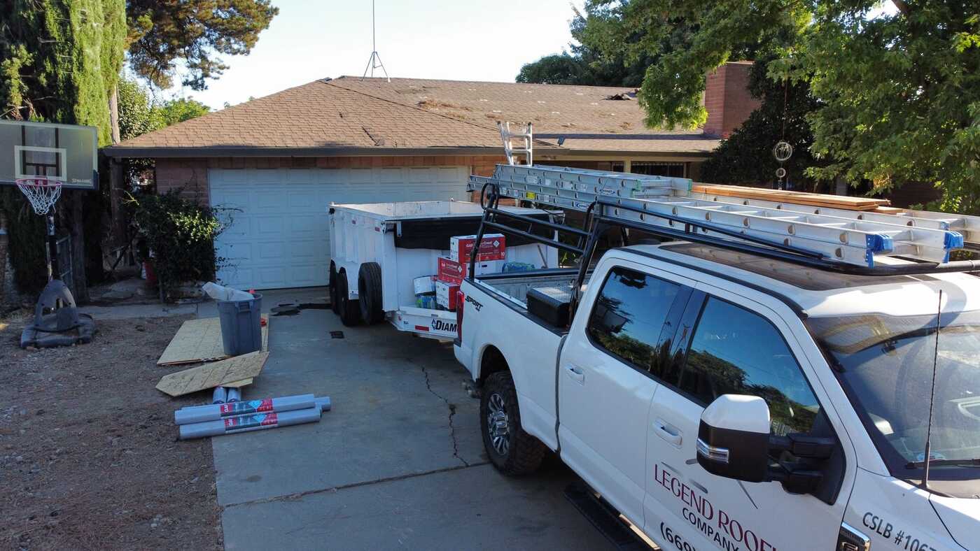 Legend Roofing truck and dump trailer on a job