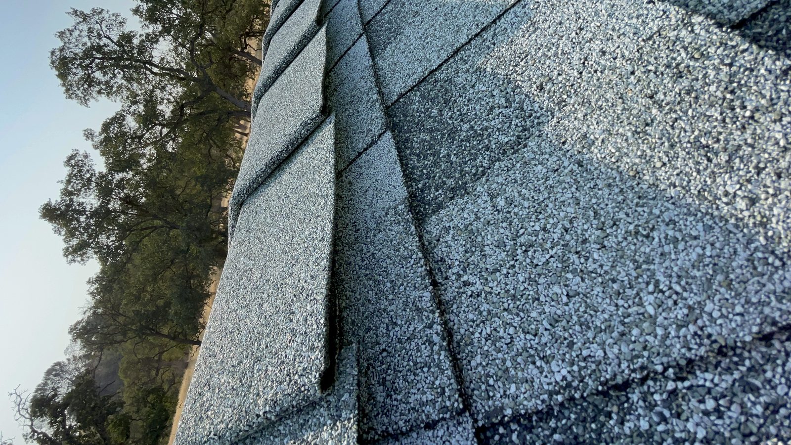 Close view of gray asphalt shingles and ridge caps on a Central Valley roof