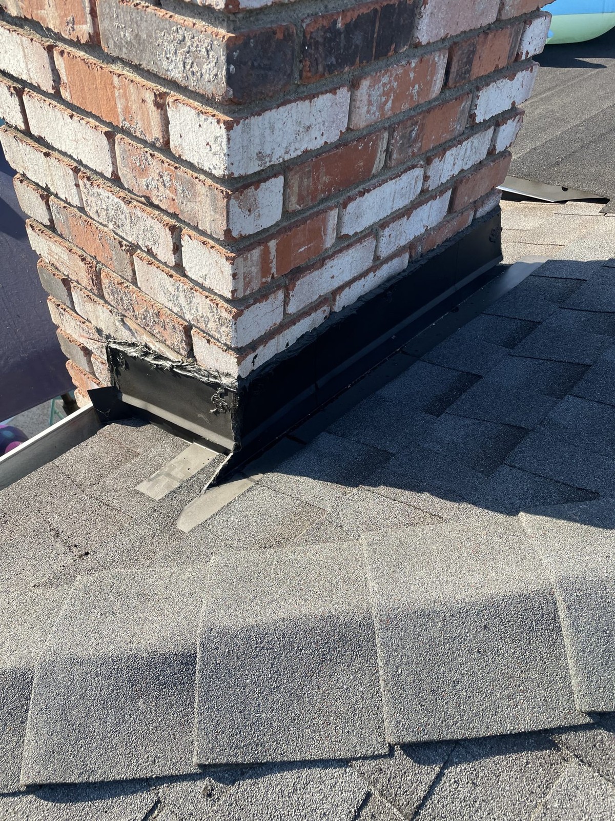 Brick chimney with step and counter-flashing