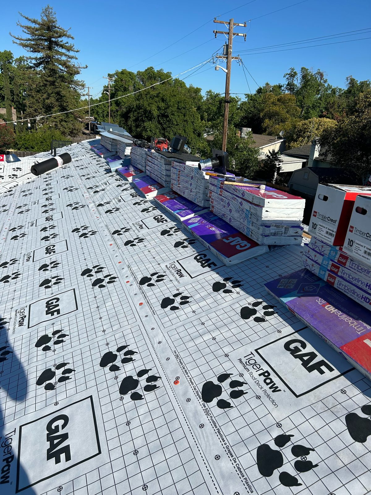 GAF Tiger Paw underlayment and Timberline HDZ bundles near a ridge