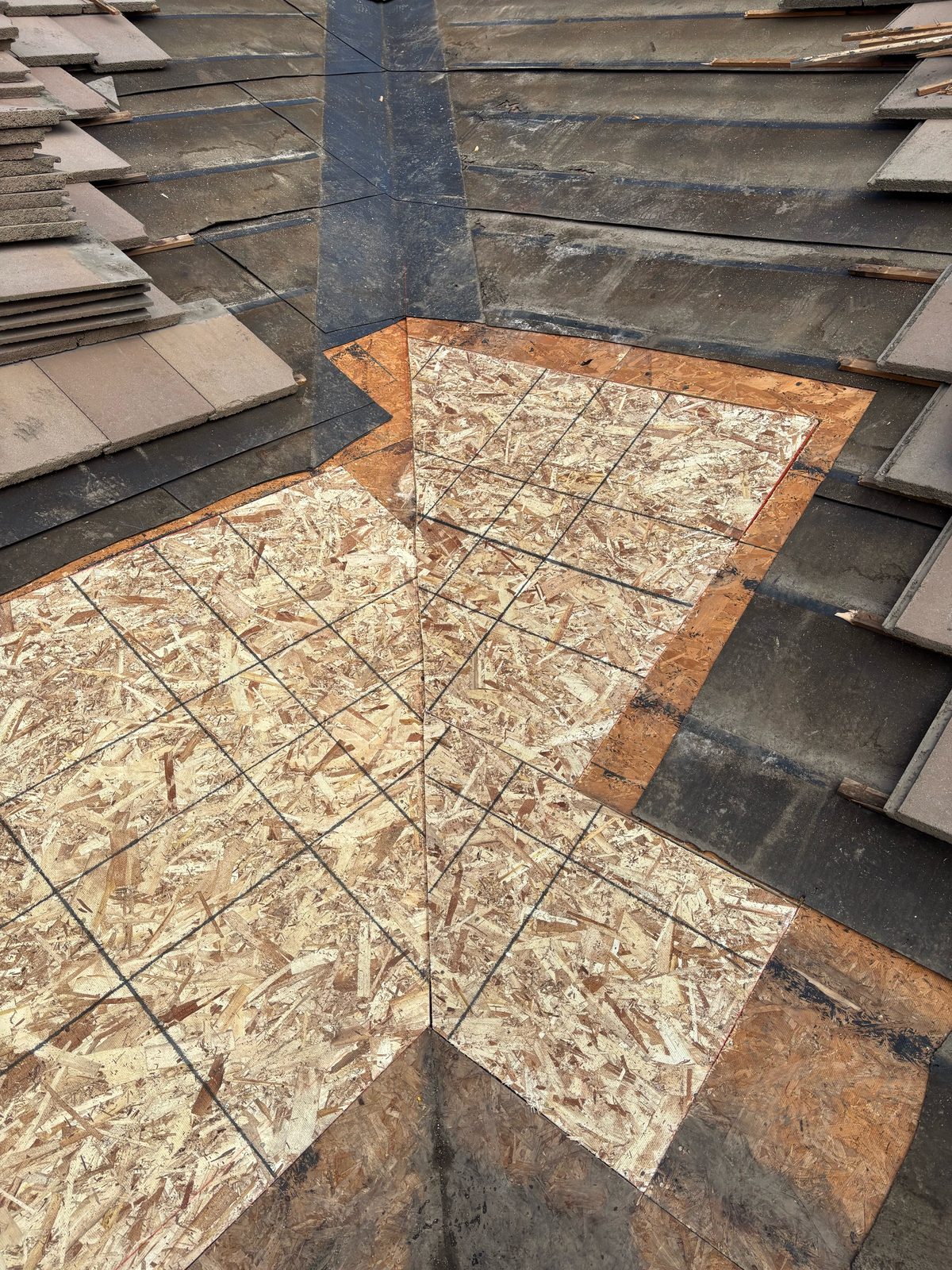 Fresh OSB sheathing cut into a Ripon tile roof valley after soft, rotted deck was removed