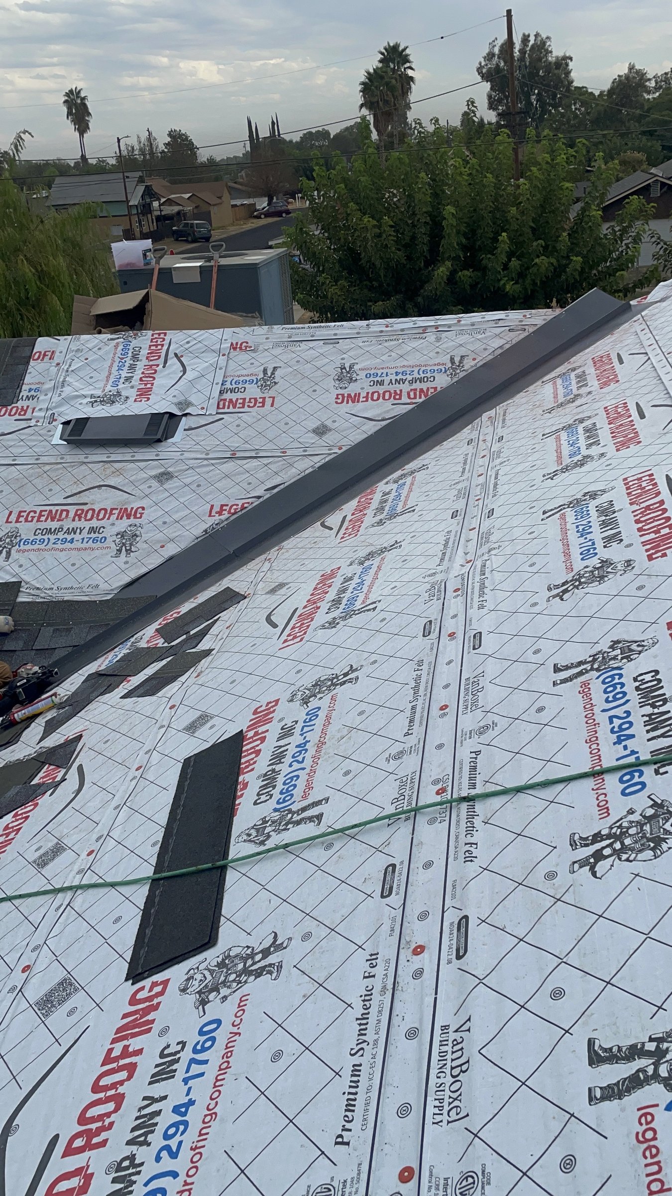 Modesto asphalt-shingle roof valley with underlayment and dark metal valley flashing