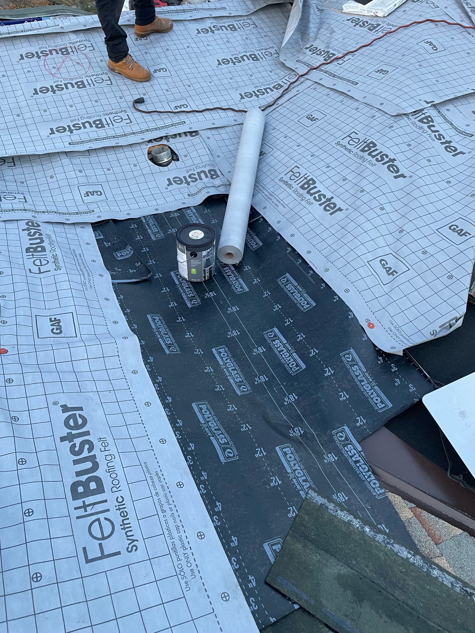 Close-up of a Modesto roof valley dry-in with GAF FeltBuster synthetic felt and black Polyglass self-adhered membrane over metal valley flashing before shingles
