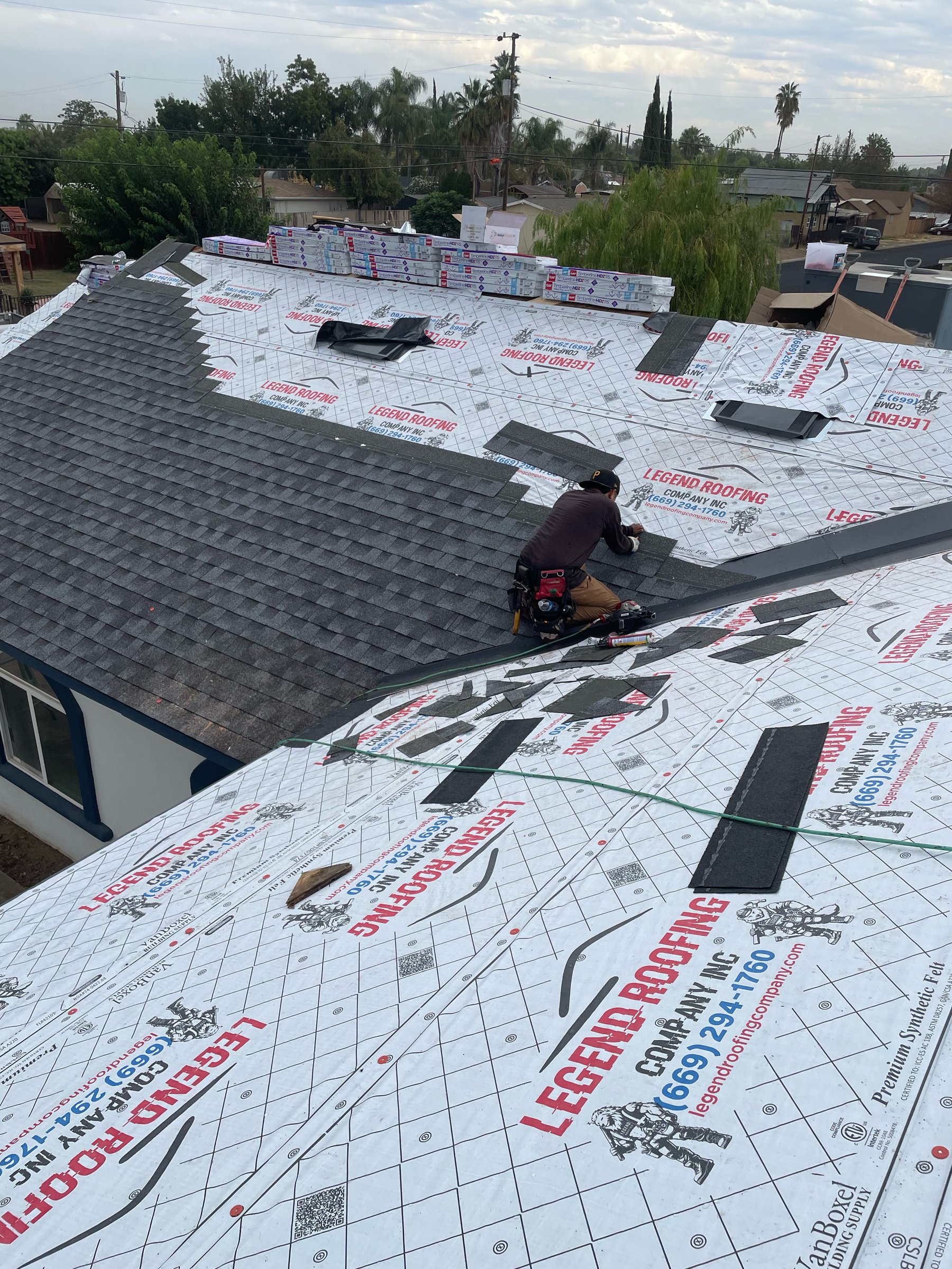Legend Roofing crew member nailing Copper Canyon architectural shingles along a Modesto roof valley over GAF FeltBuster underlayment