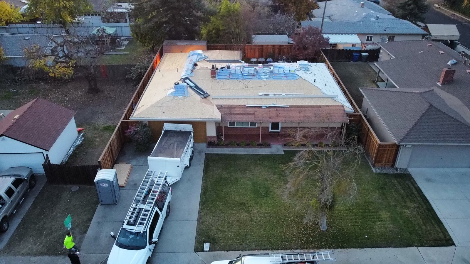 Drone view of a Modesto home mid re-roof with fresh OSB deck and GAF Grand Sequoia designer shingle bundles staged by Legend Roofing Company Inc
