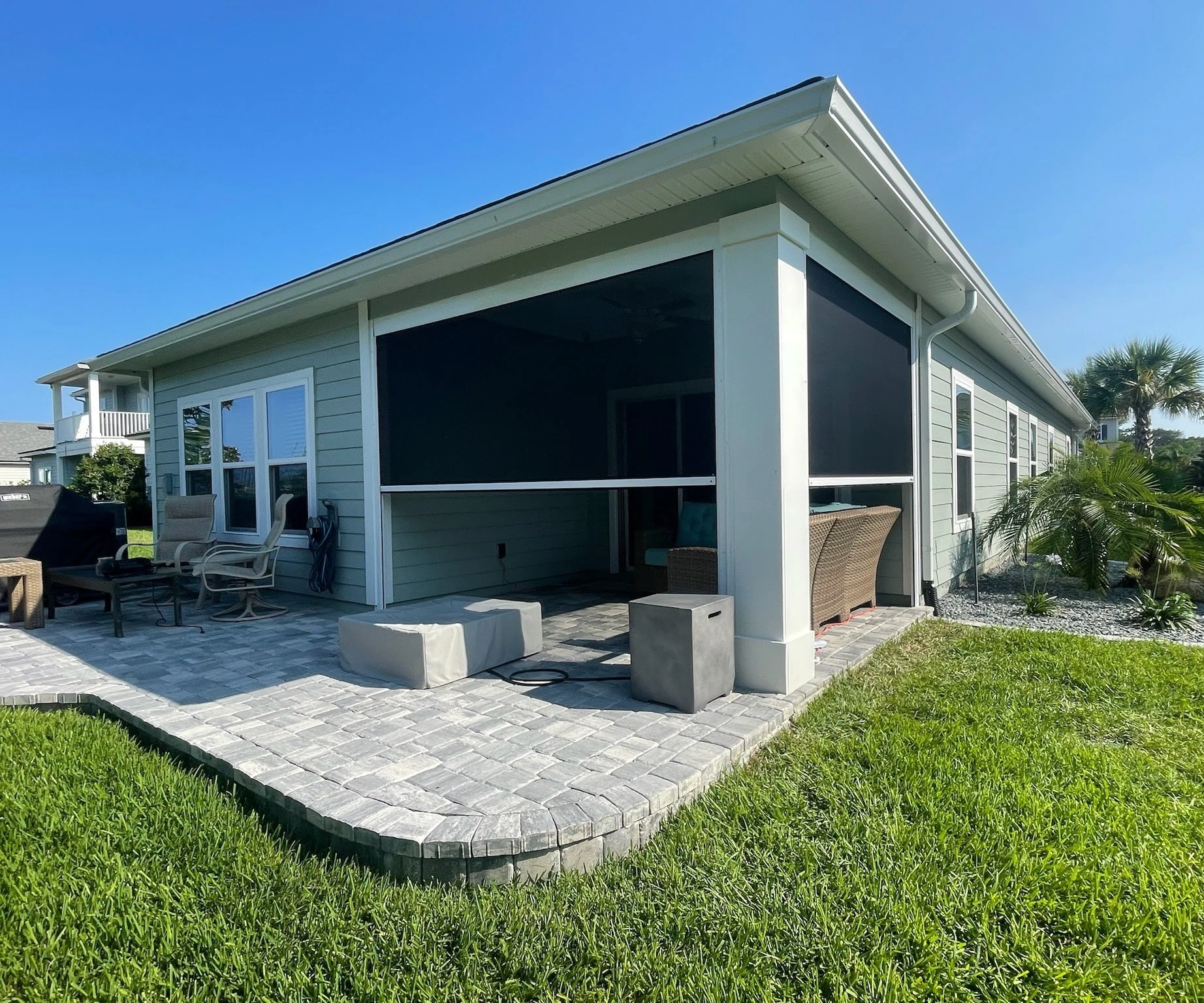 MaxForce motorized hurricane screens lowered over a covered back patio on a Florida home