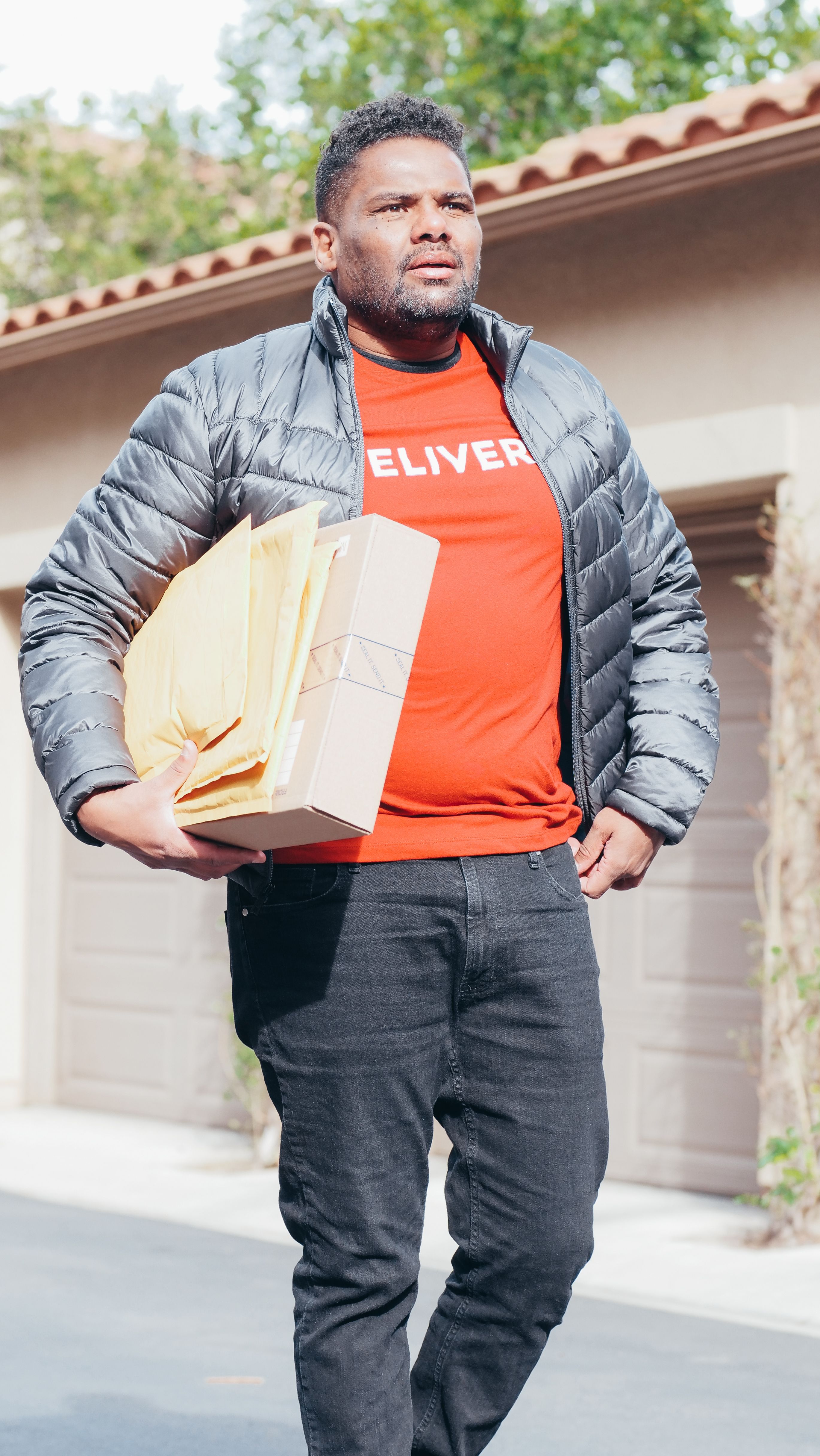 A real delivery professional carrying finished mail pieces