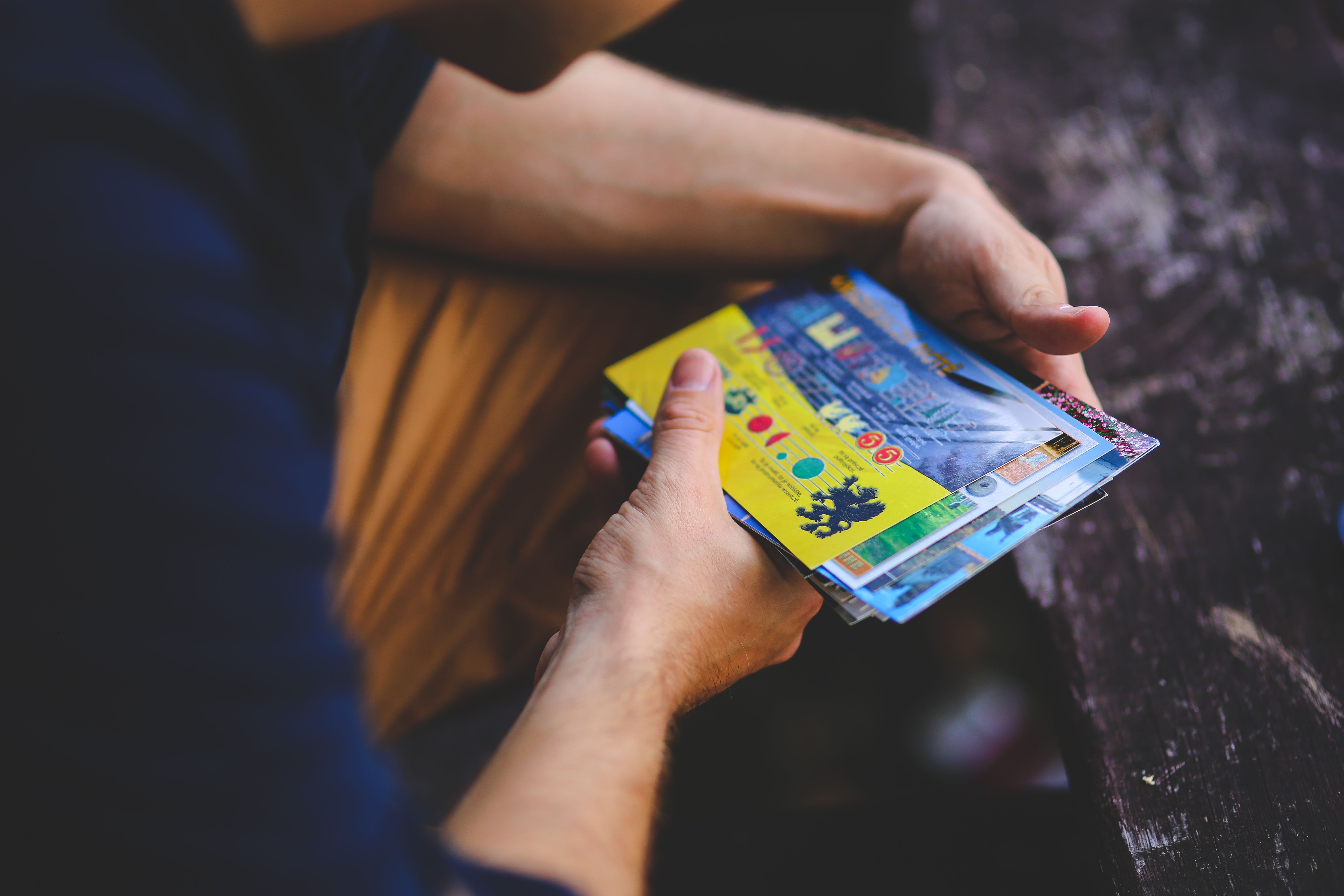A recipient holding a vivid collection of mailed postcards