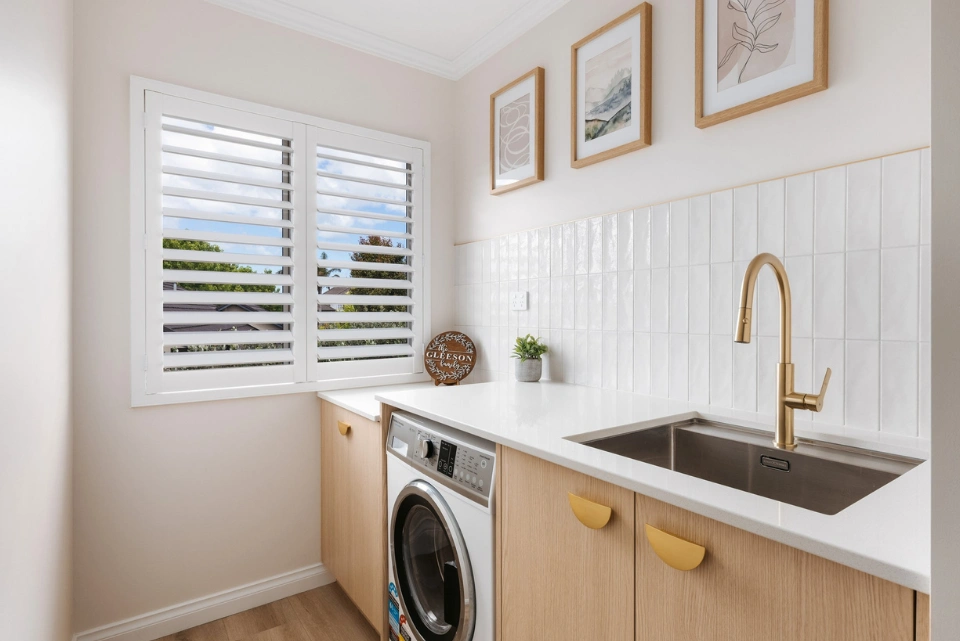 Modern laundry room design in Tauranga with built-in storage and bench space