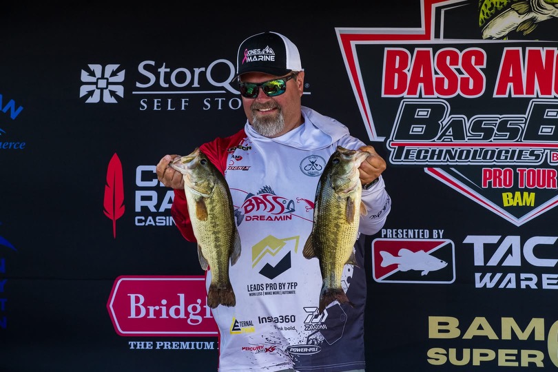 Sam holding two bass at a weigh-in