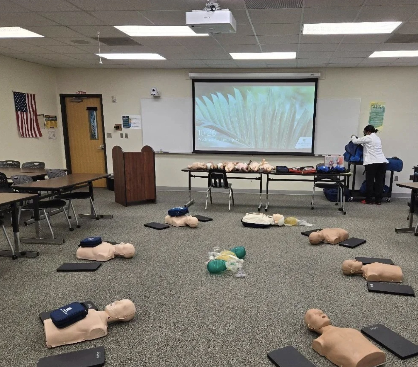 CPR mannequins arranged for classroom training with the instructor at the front of the room