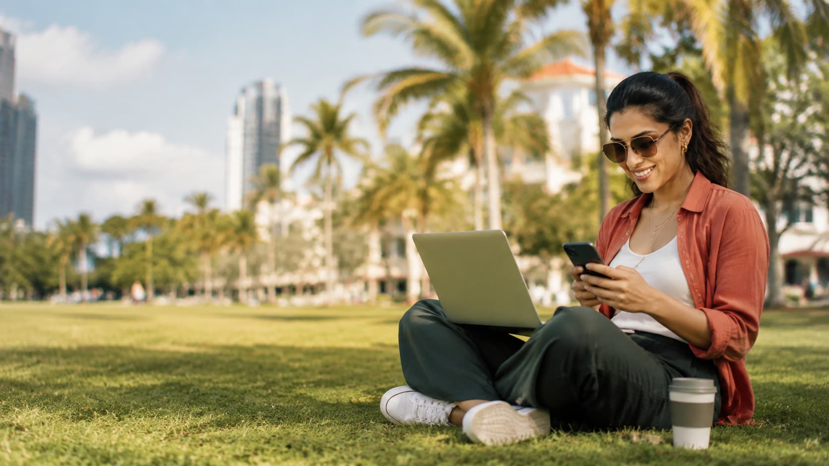 A woman working on a laptop in a Miami park