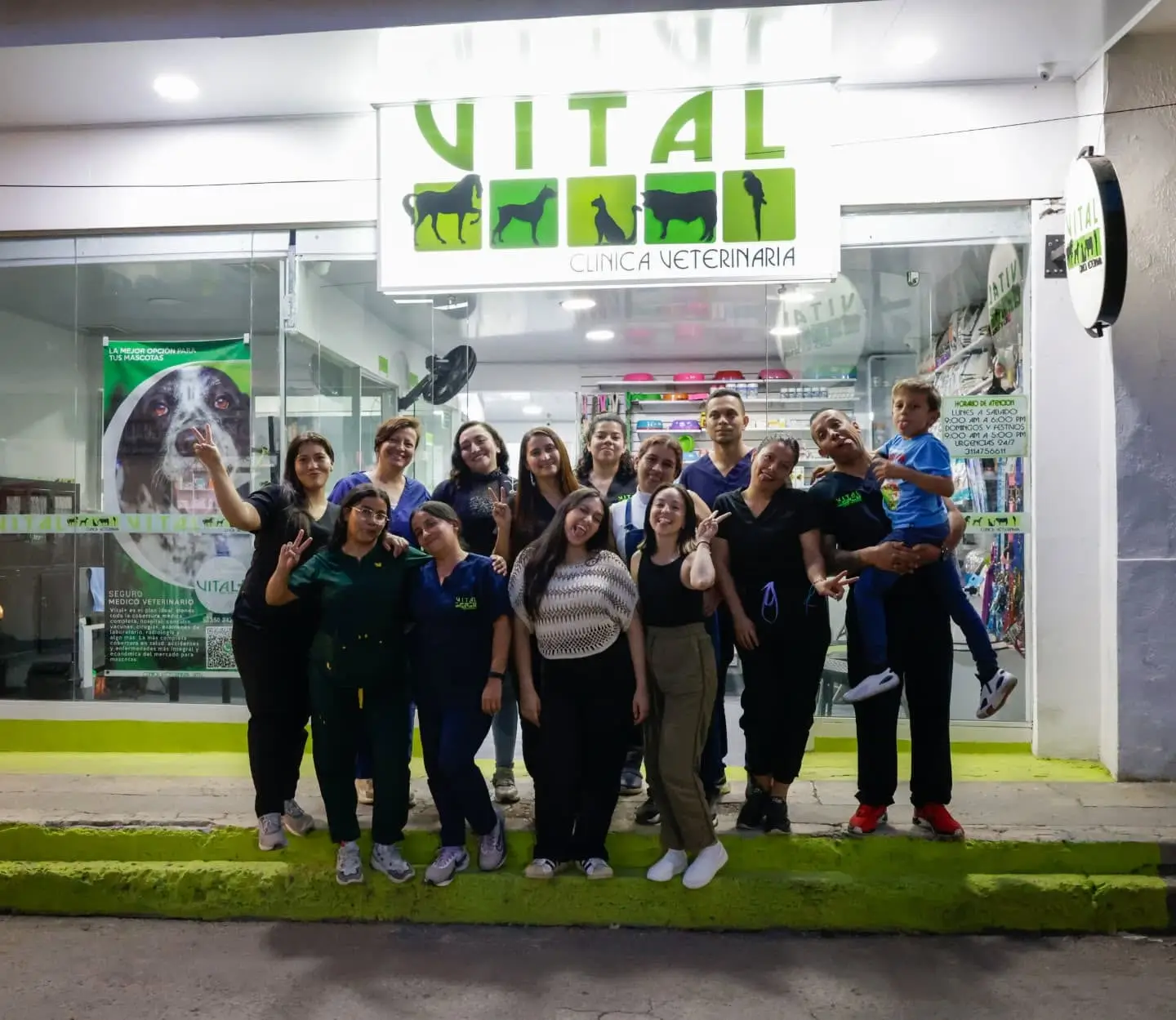 Equipo de Clinica Veterinaria Vital Villeta reunido frente a la fachada de la sede, bajo el letrero de VITAL.