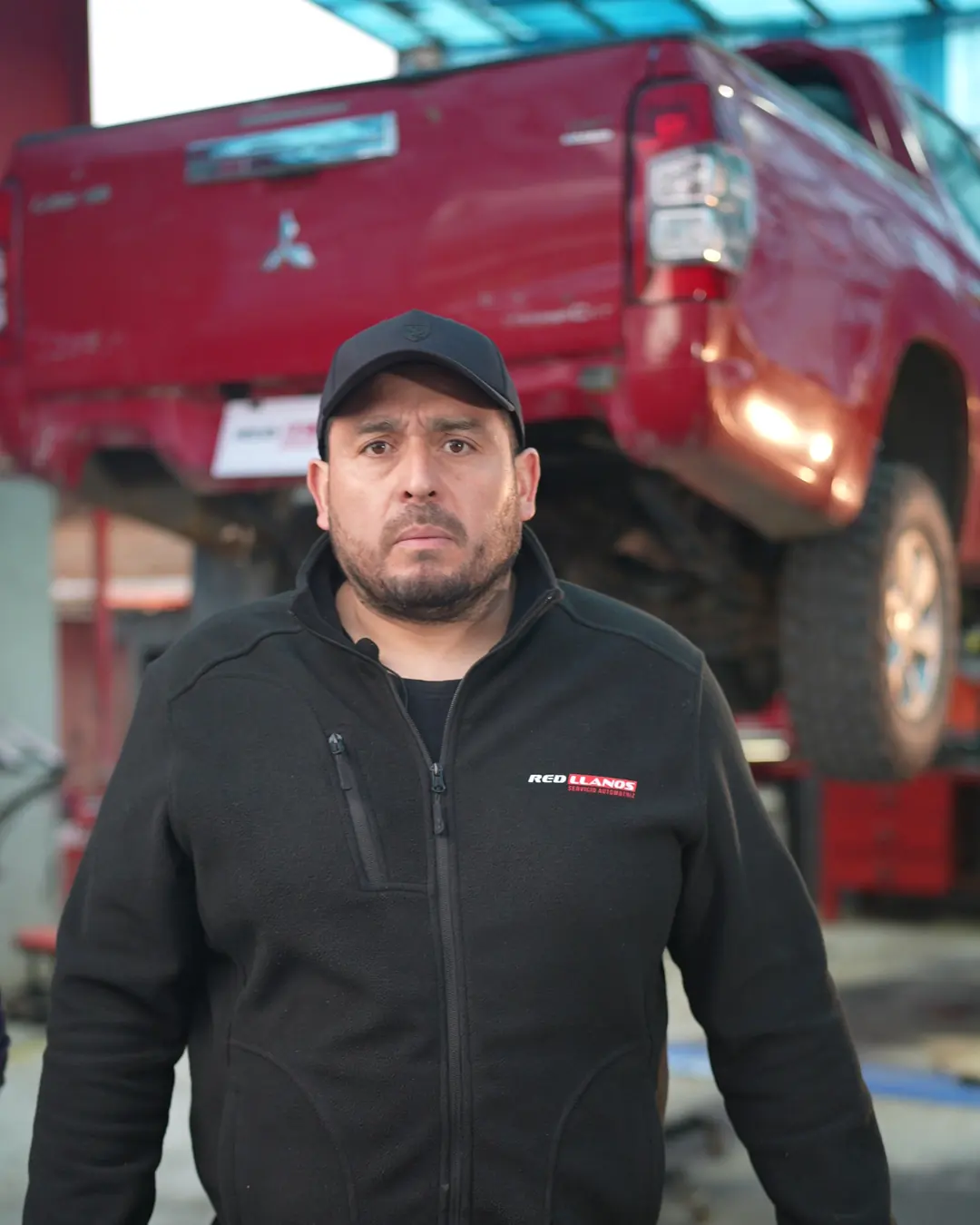 Camilo, dueño de Red Llanos, en el taller con una camioneta diésel en el elevador