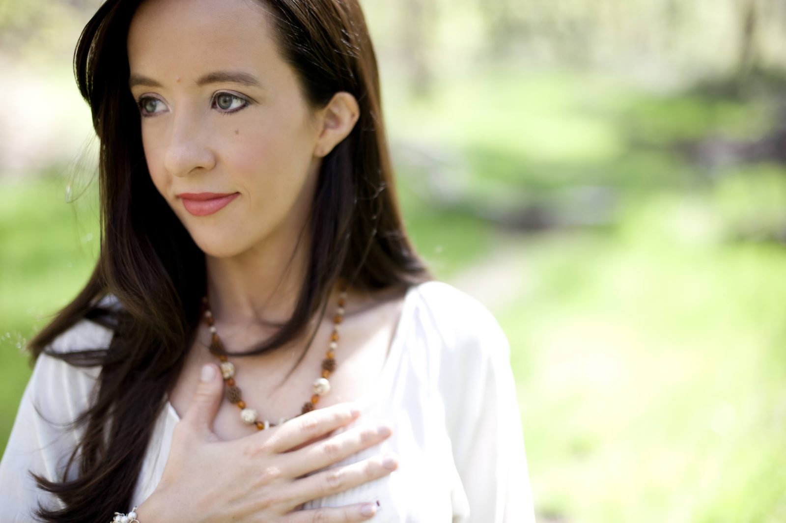 Close portrait of Mindie with her hand over her heart