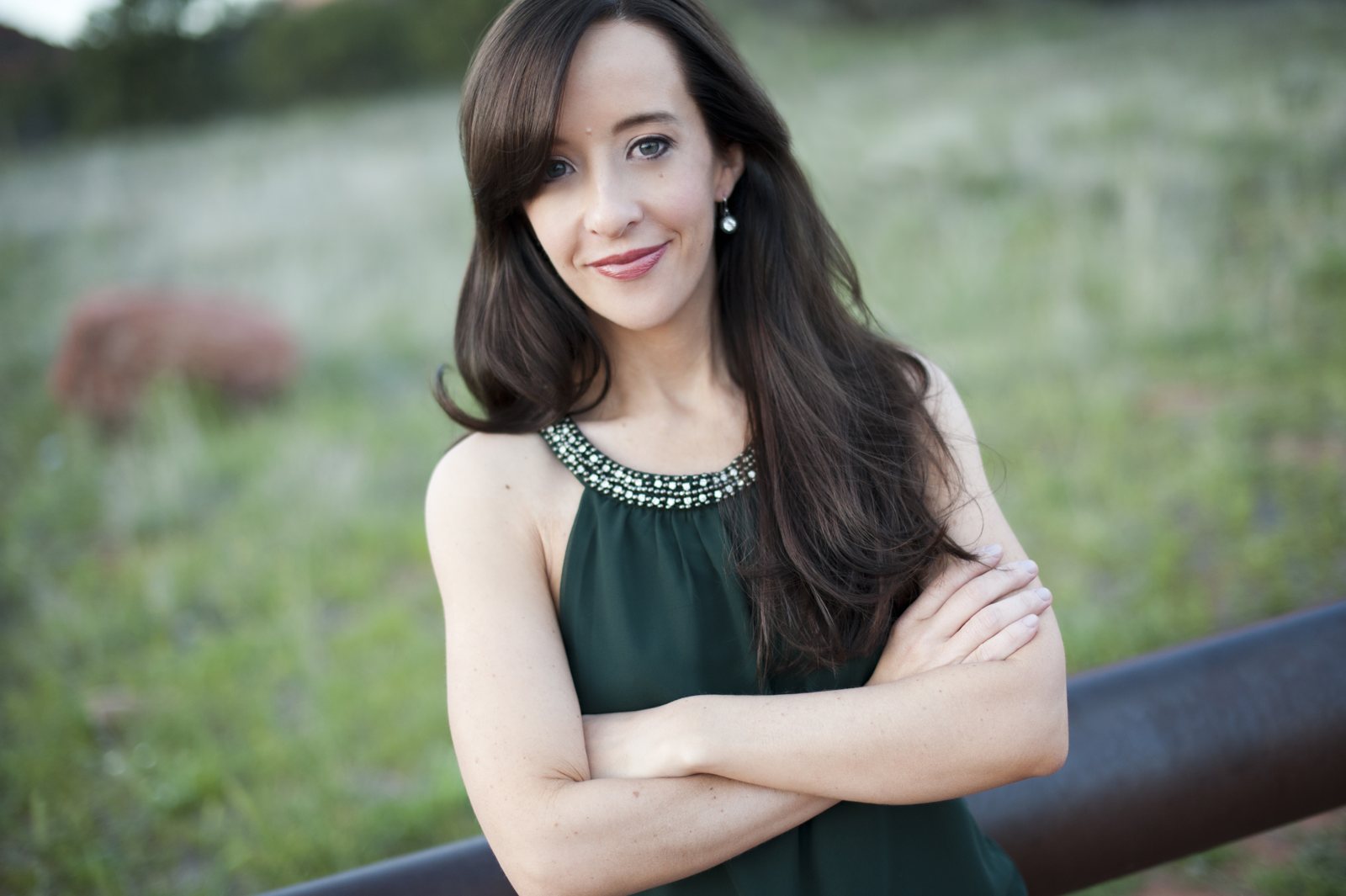 Mindie Kniss in a green top, arms crossed, looking at the camera
