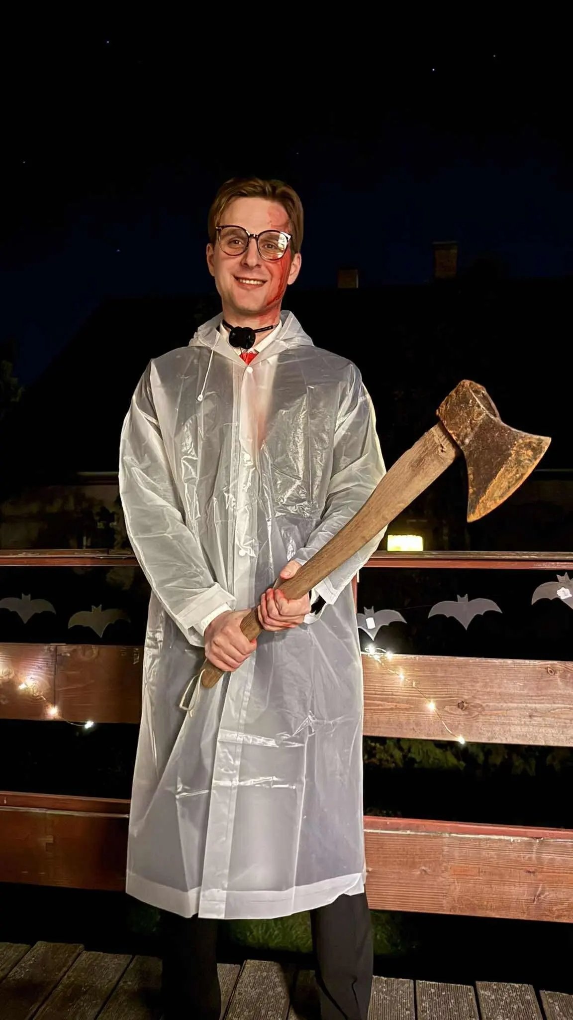 Jess dressed as Patrick Bateman from American Psycho for Halloween with raincoat and axe
