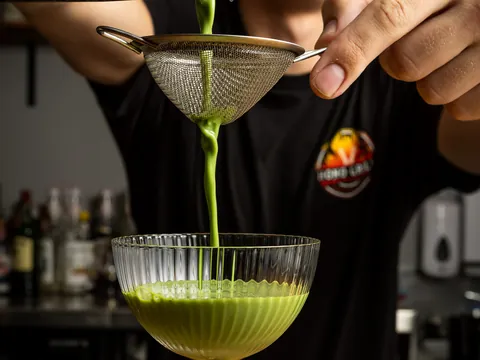 A green drink strained into a coupe at the Hono Grill bar