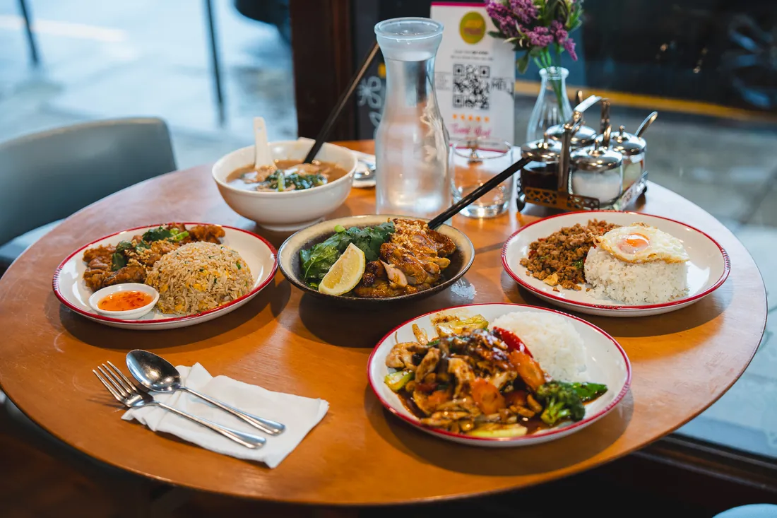 A round window table set with soup, fried rice and stir-fries
