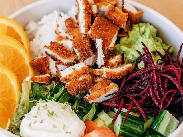Crumbed chicken bowl with rice, orange, beetroot and a poached egg, top-down