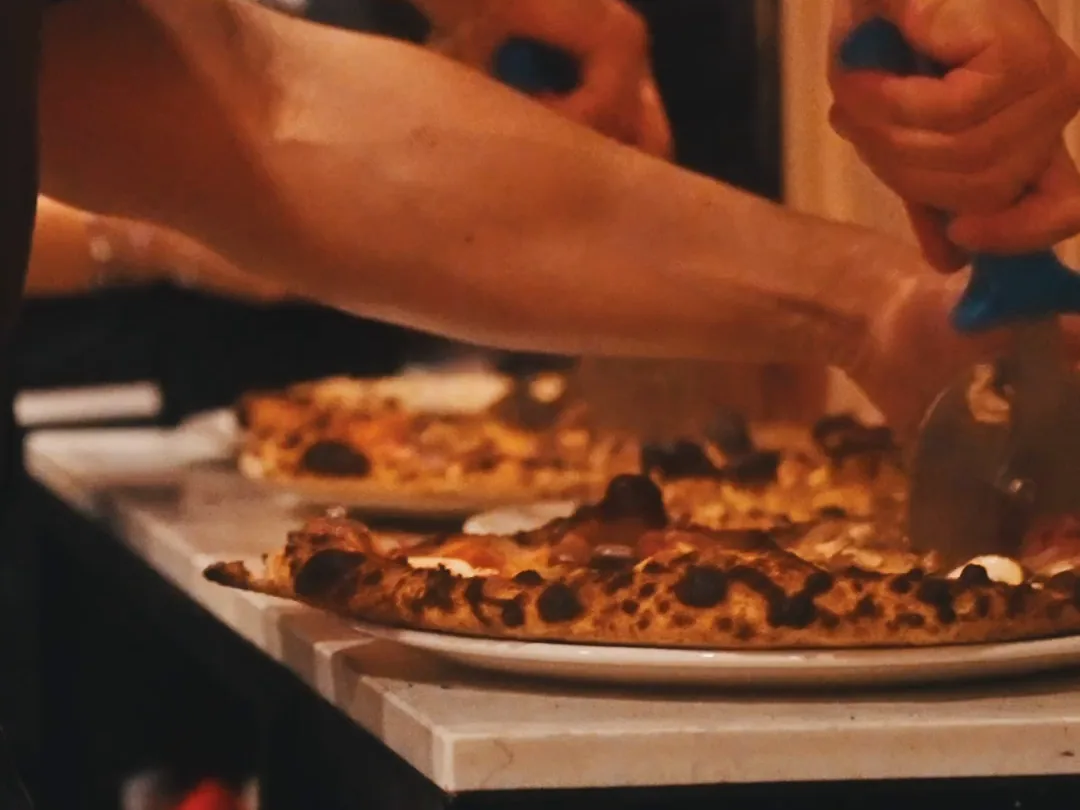 A frame from a real Served video ad: a pizza cut into slices on the board at Pizzicotto&rsquo;s pass