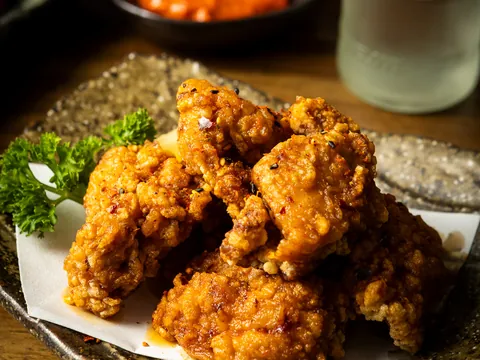 A pile of golden karaage fried chicken on a stone plate