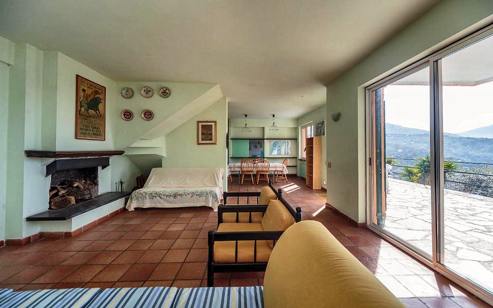 Soggiorno con camino e vetrata sulla terrazza vista mare
