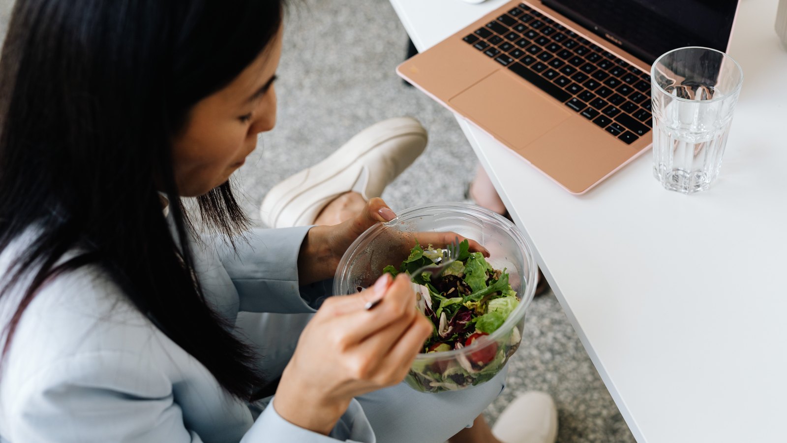 Woman eating a salad at her desk