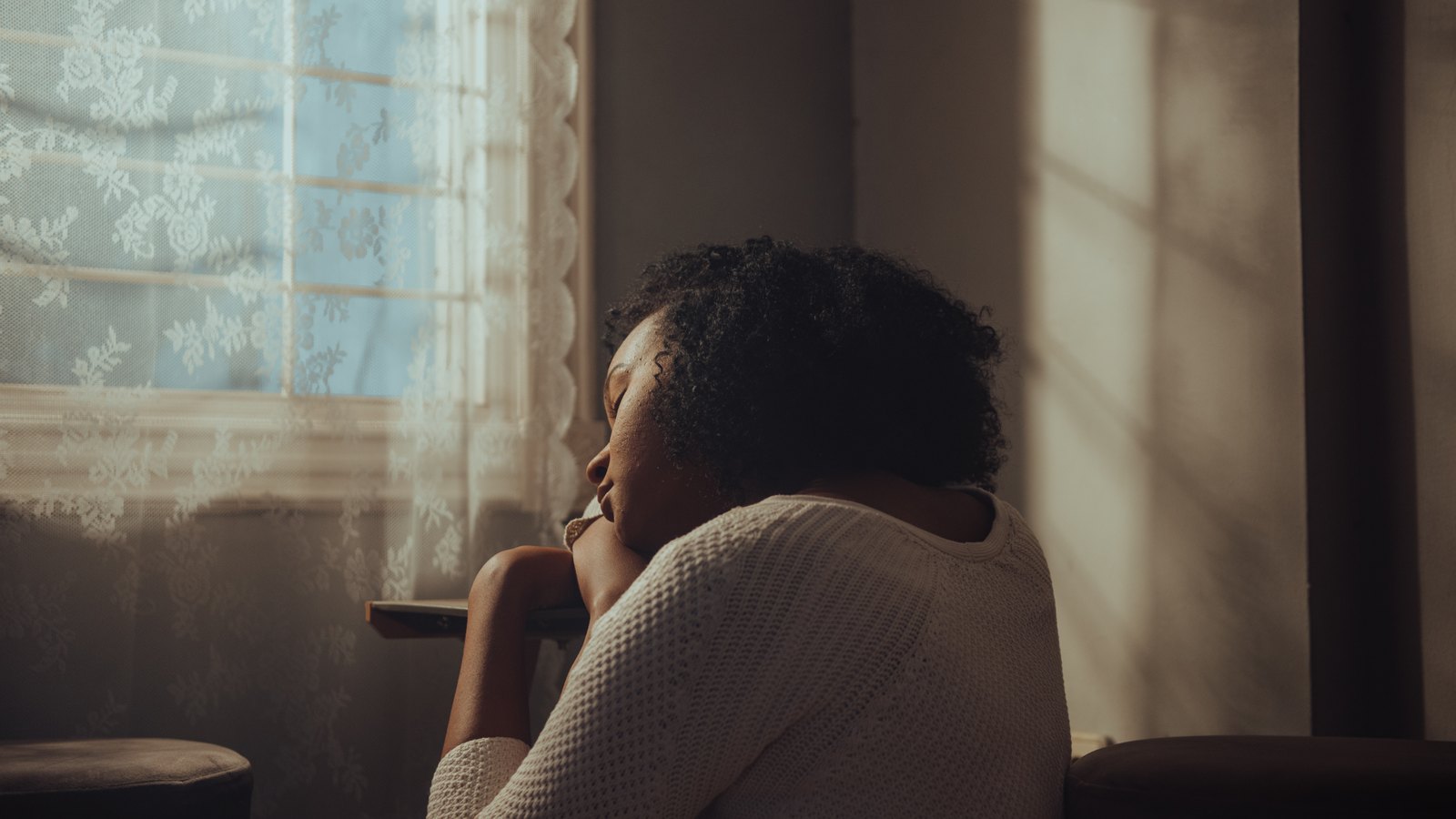 Woman sitting alone by a window