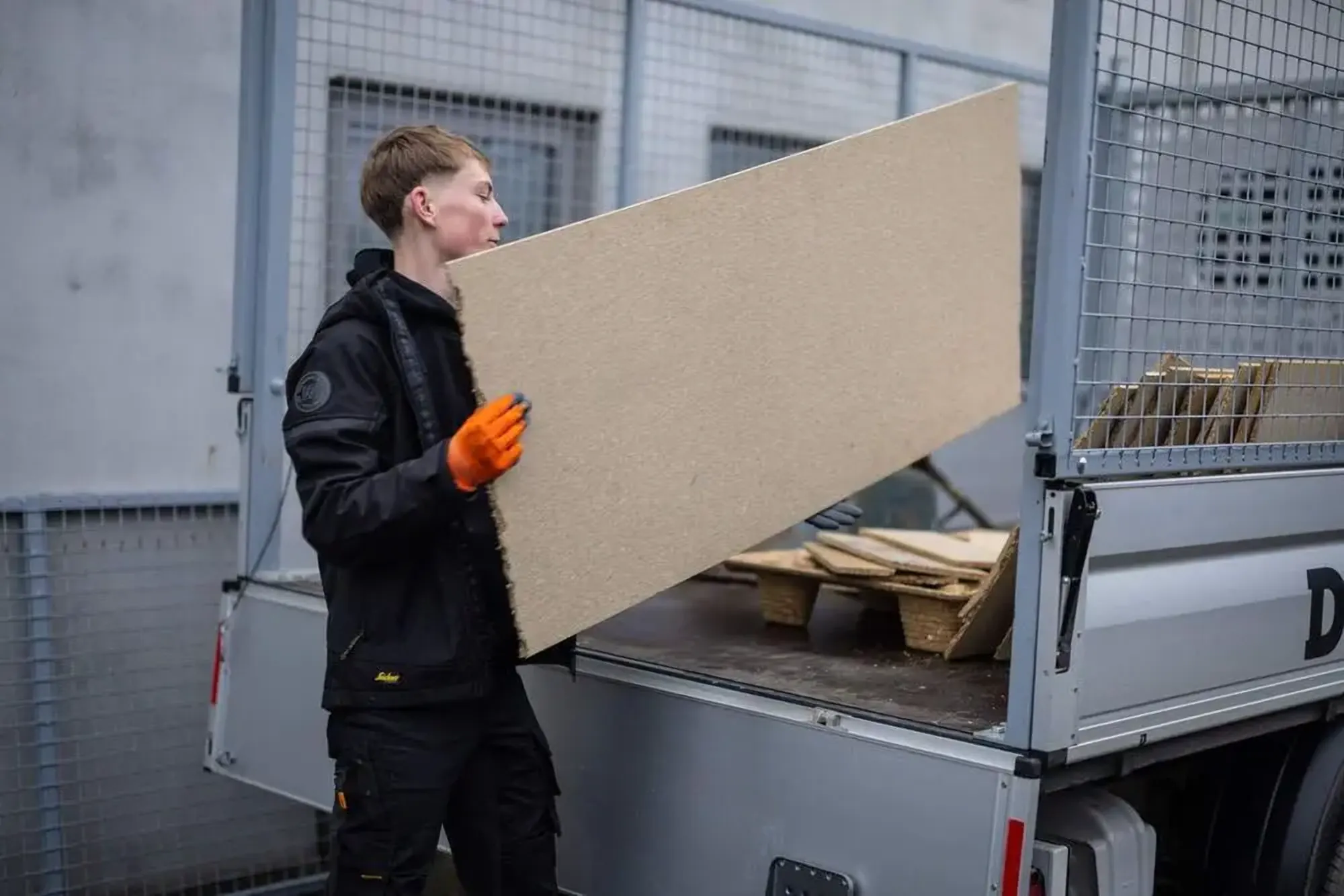 Medewerker van Damagmee laadt rommel in de werkbus
