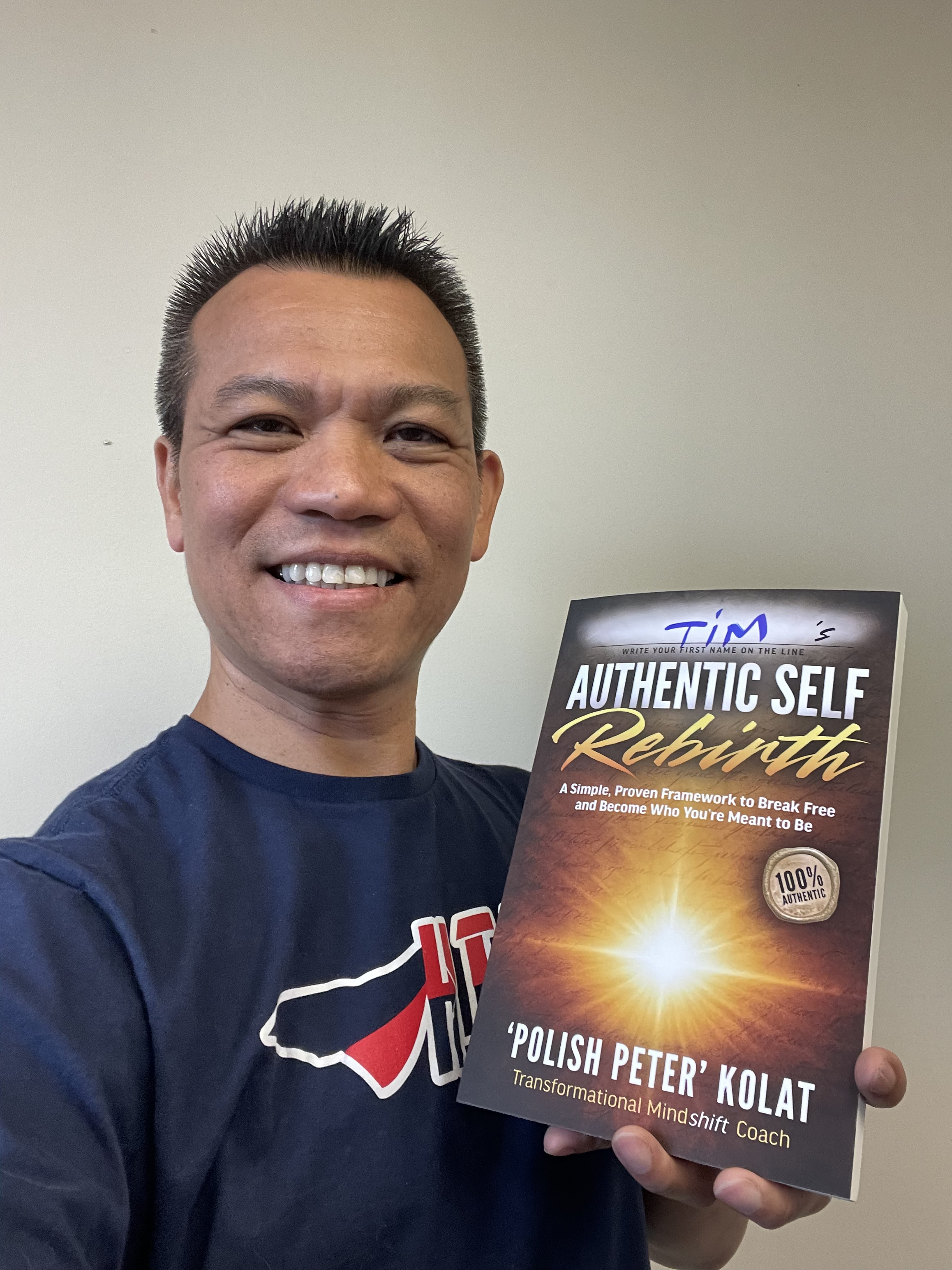 A reader holding Authentic Self Rebirth with his name written on the cover