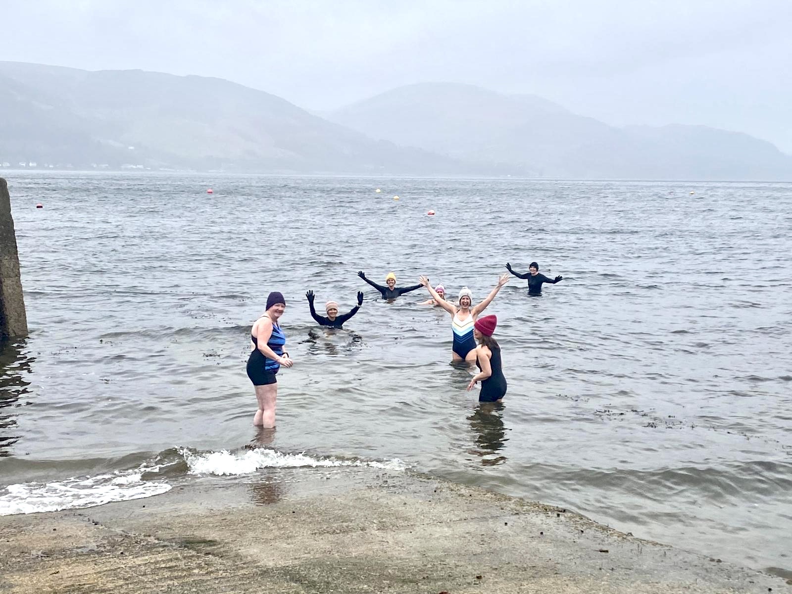 Group of women in a Scottish loch, arms raised