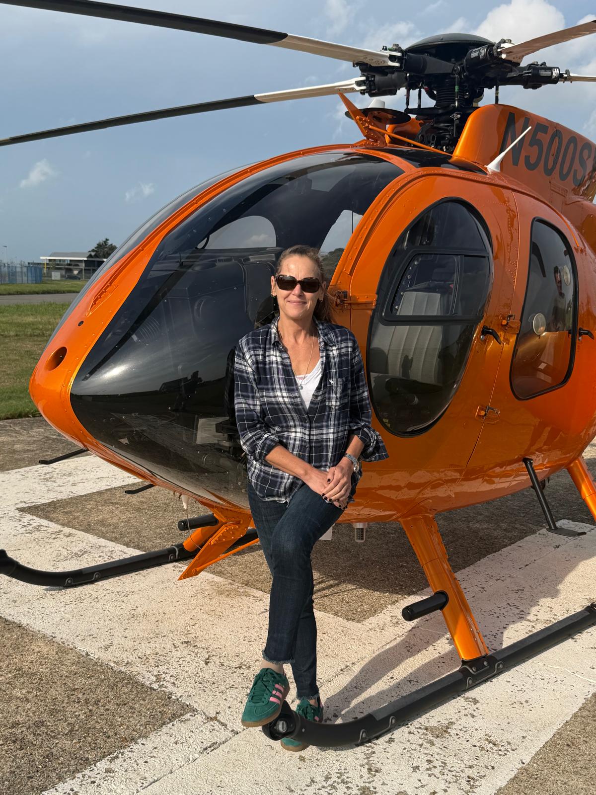 Alexandra Johnson standing beside an orange helicopter