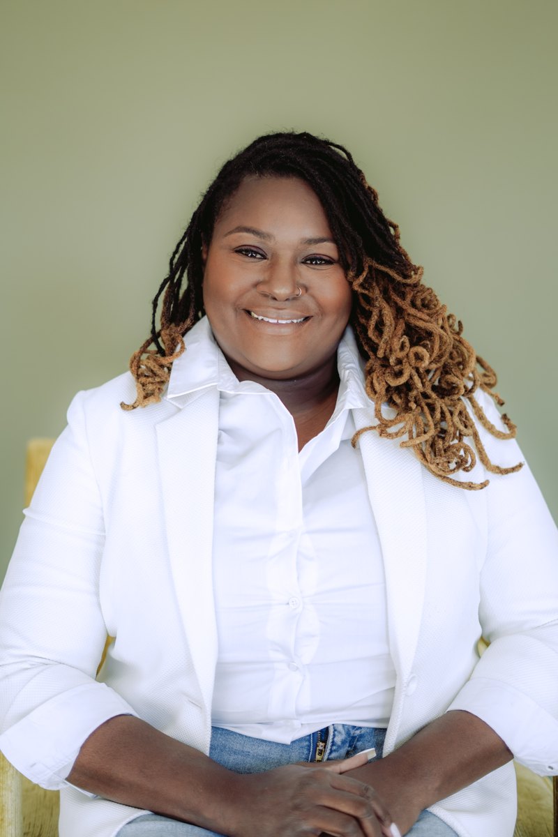Starr Clinton smiling in a white blazer