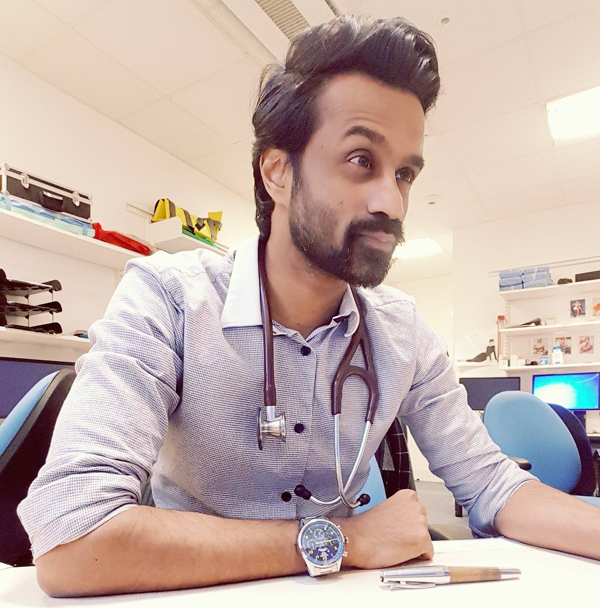 Dr Neel Reddy writing at his desk