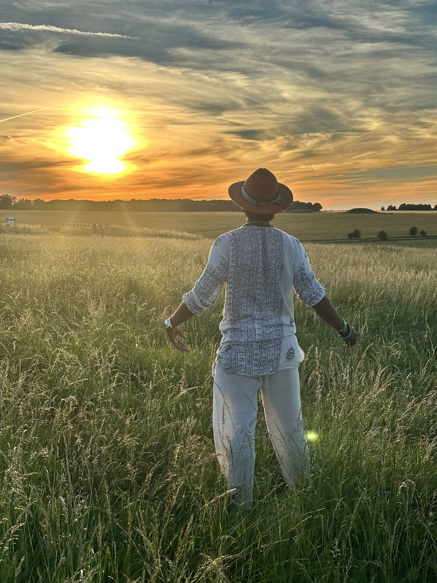 A figure in a field at sunset