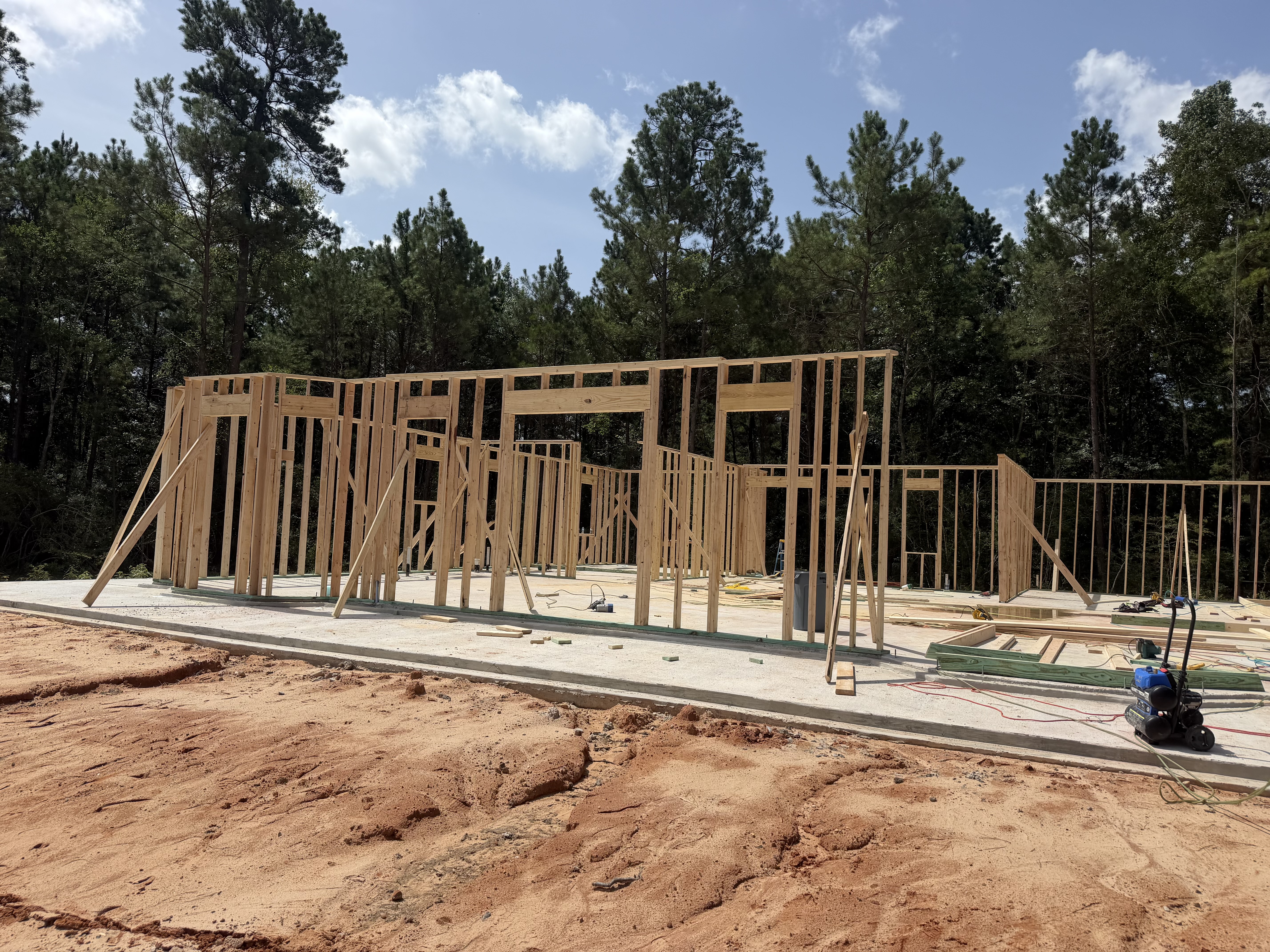 Custom home framing under construction with active jobsite oversight