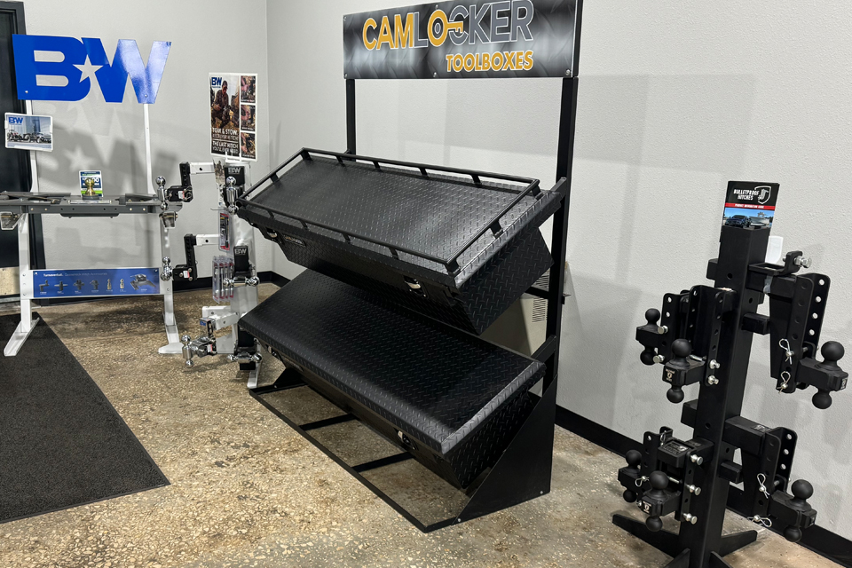Truck accessory display with bed racks and hitch products inside the Precision Off Road showroom