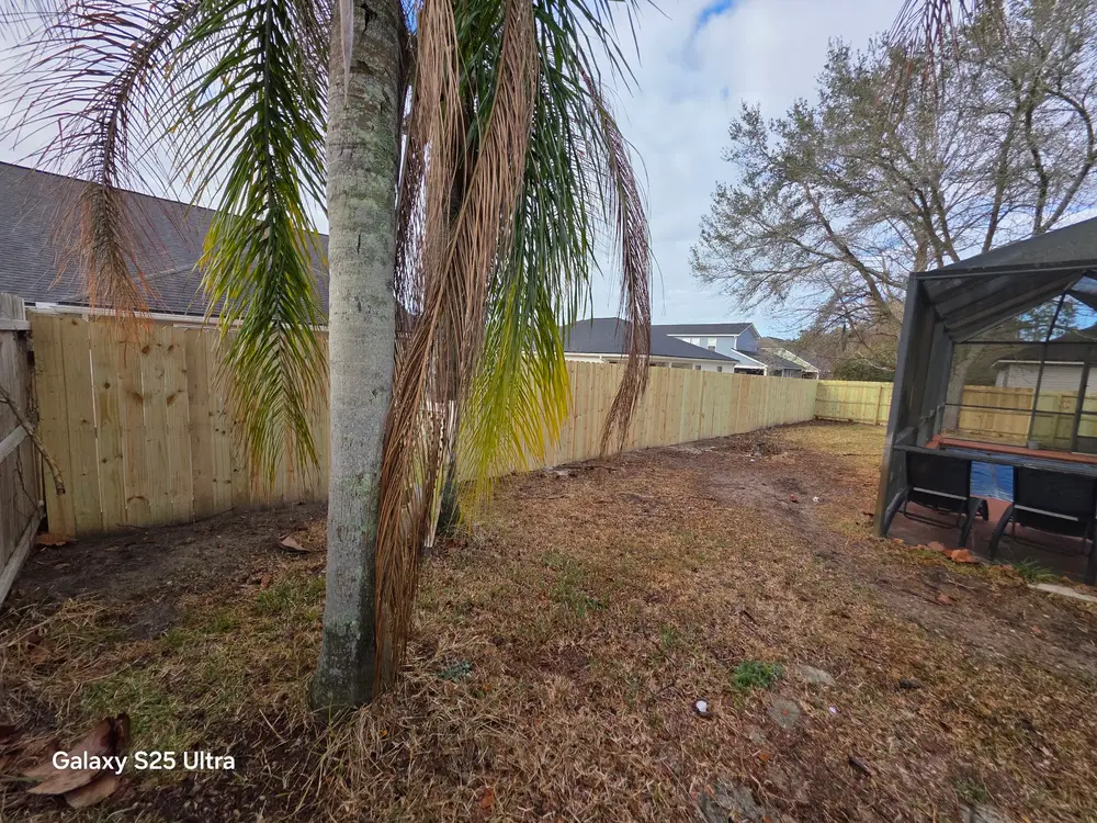 Modern metal automatic gate installation in St. Augustine, FL, set in a landscaped property with lush lawns.