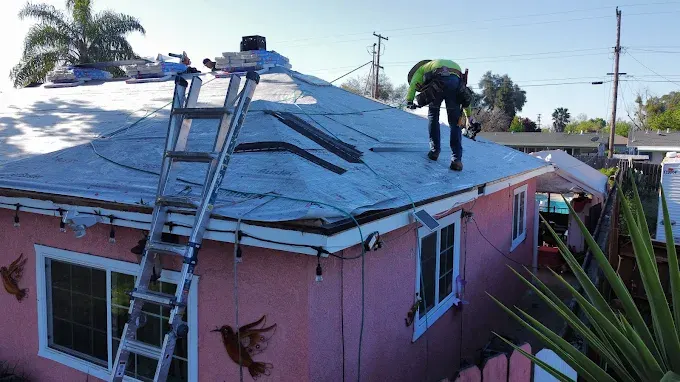 Residential roofing in Modesto with asphalt shingles, detailed craftsmanship, lush landscaping, and clear blue sky