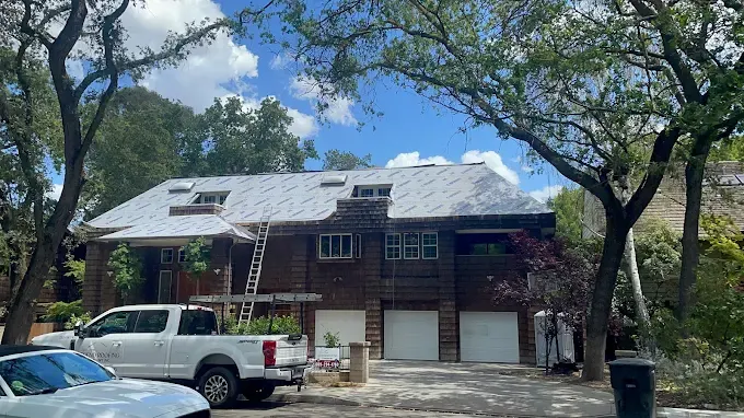 Repaired wind-damaged roof on a modern home in Modesto California with new flashing sealed seams and clean shingles