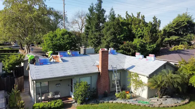 Newly replaced sealed pipe boot on a residential roof in Modesto California with detailed shingles under bright sunlight