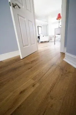 Completed flooring installation in Lehigh Acres FL featuring polished hardwood and ceramic tiles in a bright interior.