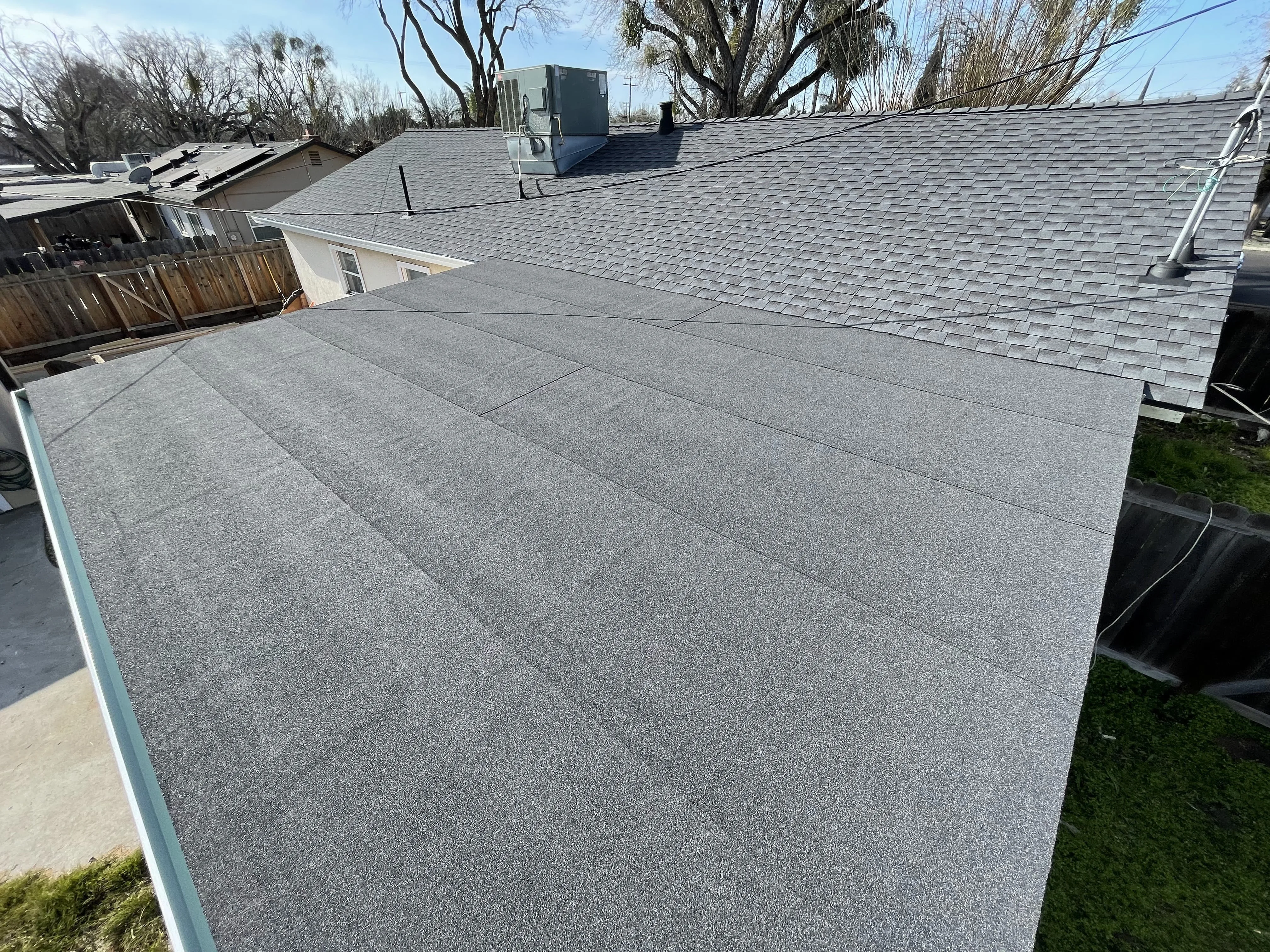Freshly completed roof replacement on a modern suburban home in Modesto CA with well-installed shingles and landscaped yard.