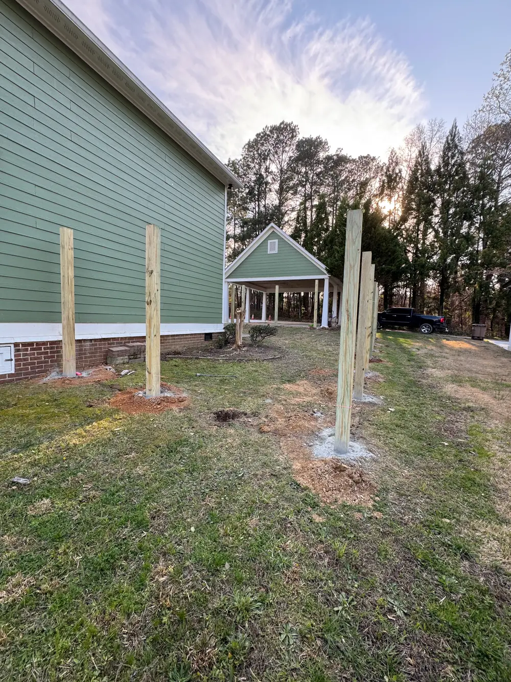 Perfectly completed wooden fence in Ringgold GA, surrounding a vibrant garden under a clear blue sky.